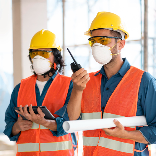 Construction workers wearing protective masks and PPE on site